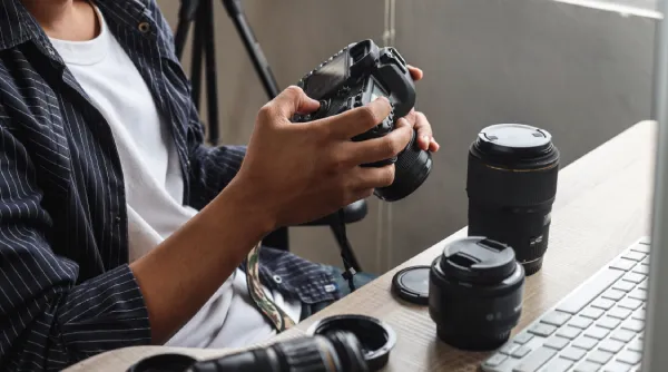 Man met camera en lenzen voor computer.webp